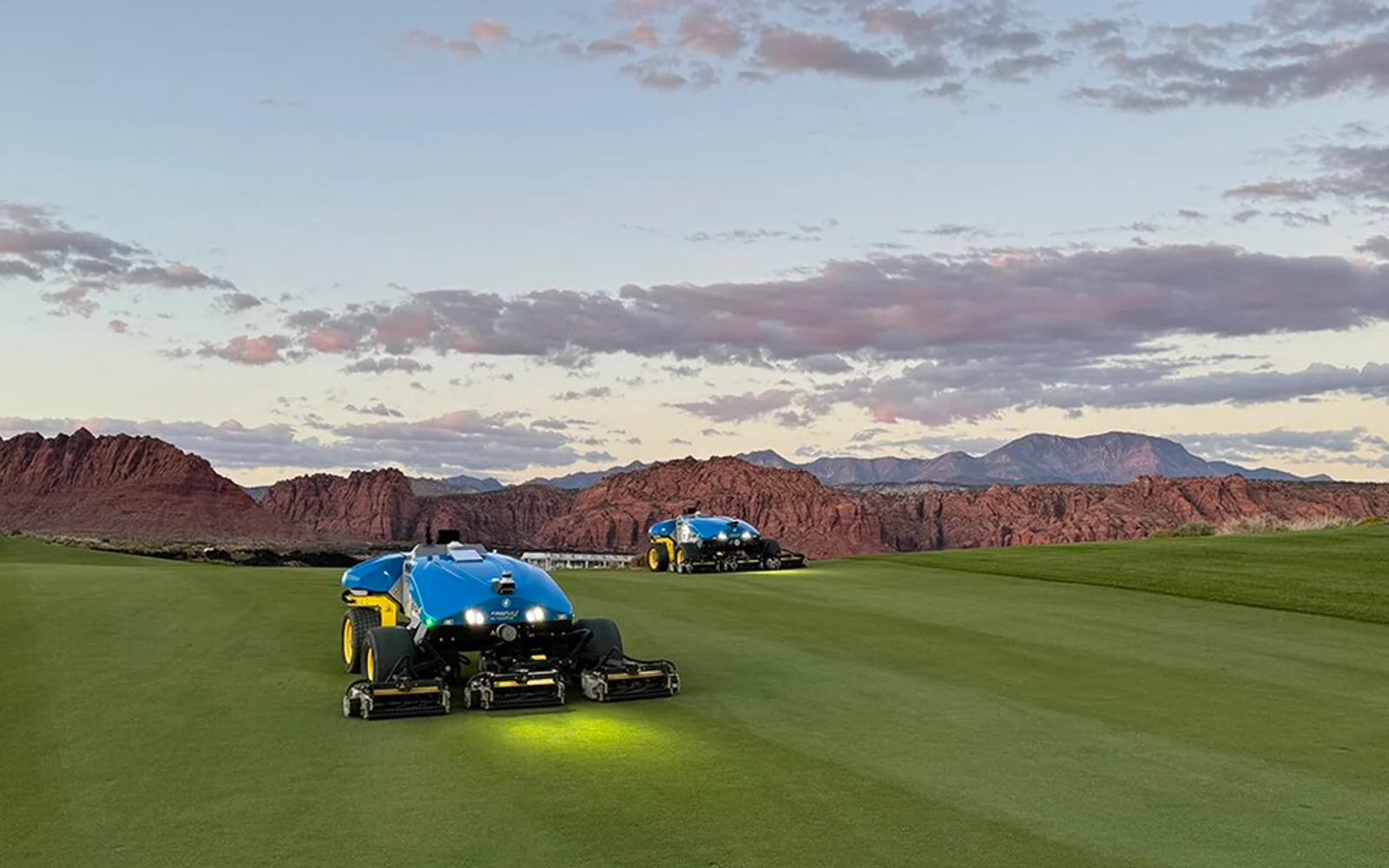 Two autonomous reel mowers cutting a golf-course fairway.