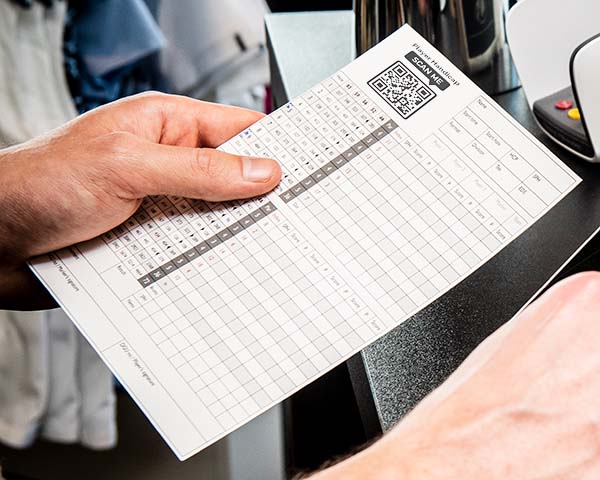A printed golf scorecard with a QR code for digital access.